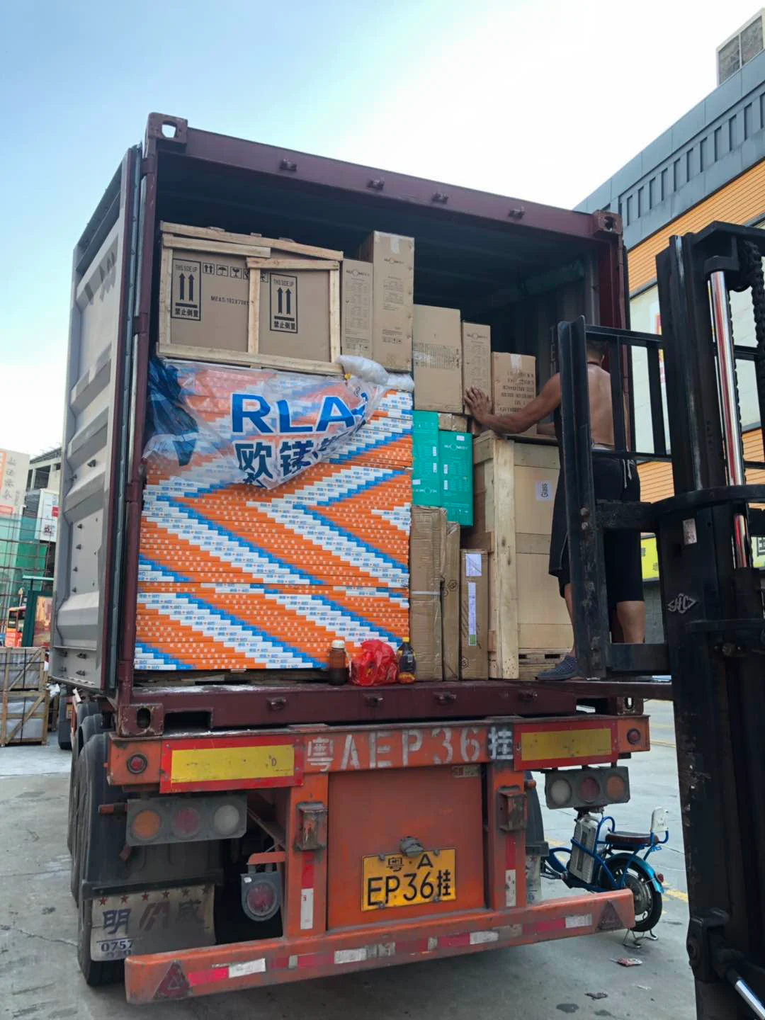 Loading building materials into shipping container at factory