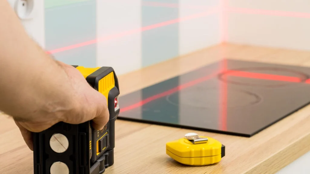 Using a laser level to project red lines over a wood countertop for precise, gap-free luxury cabinet installation.