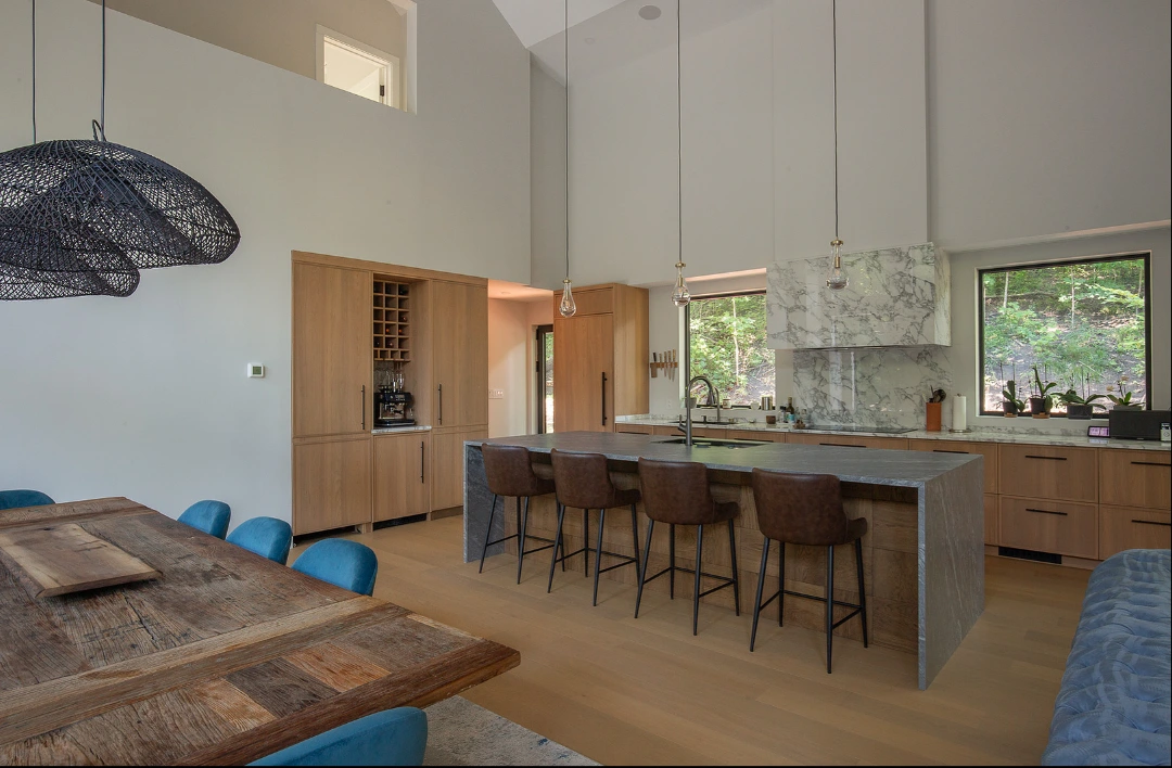 Main kitchen designed with large stone island and tall built-in wood cabinets
