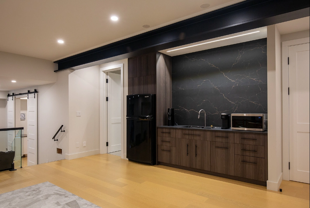 Wet bar and secondary kitchen area with dark cabinetry and black stone texture