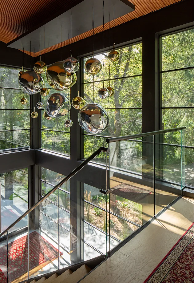 Modern staircase with glass railing and sculptural pendant lighting