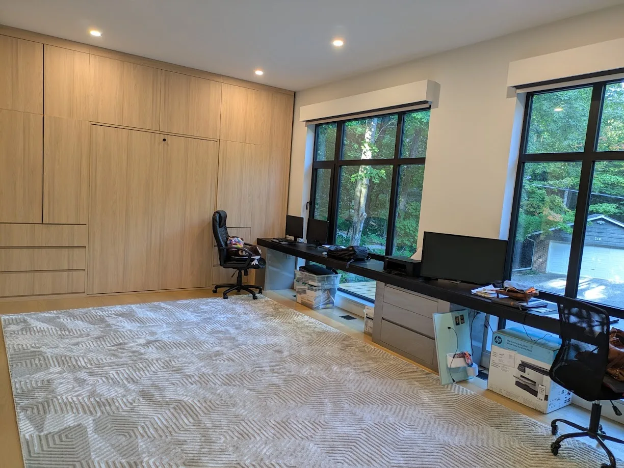 Home office with full-height built-in storage and long desk area by the window