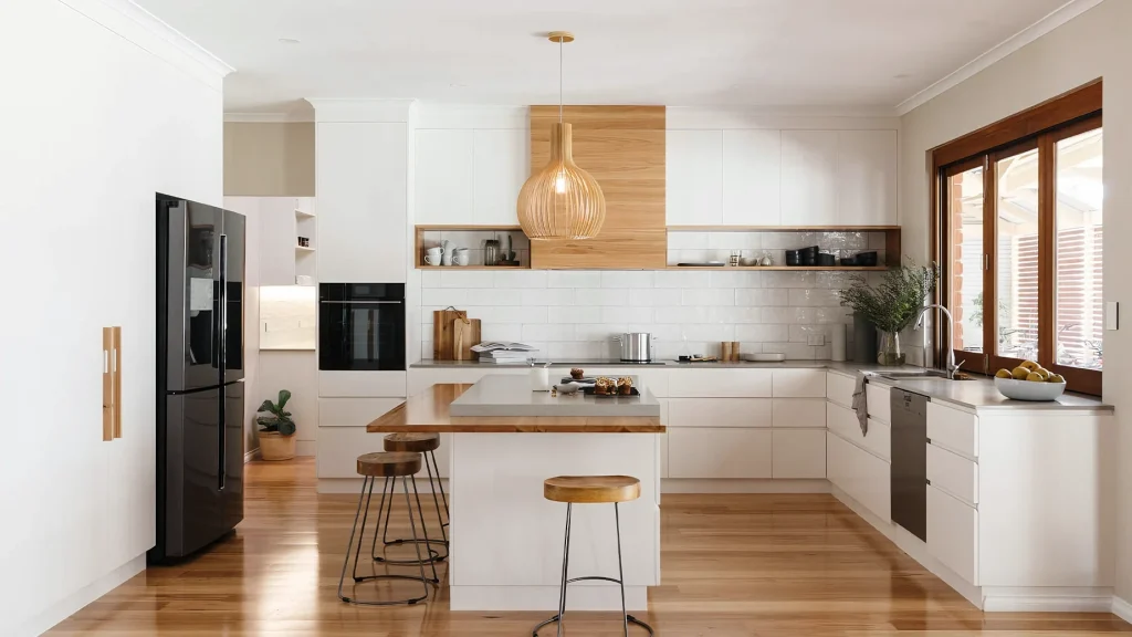 Matte warm white handleless kitchen cabinets integrated with natural wood panels, a central island, and wood flooring.