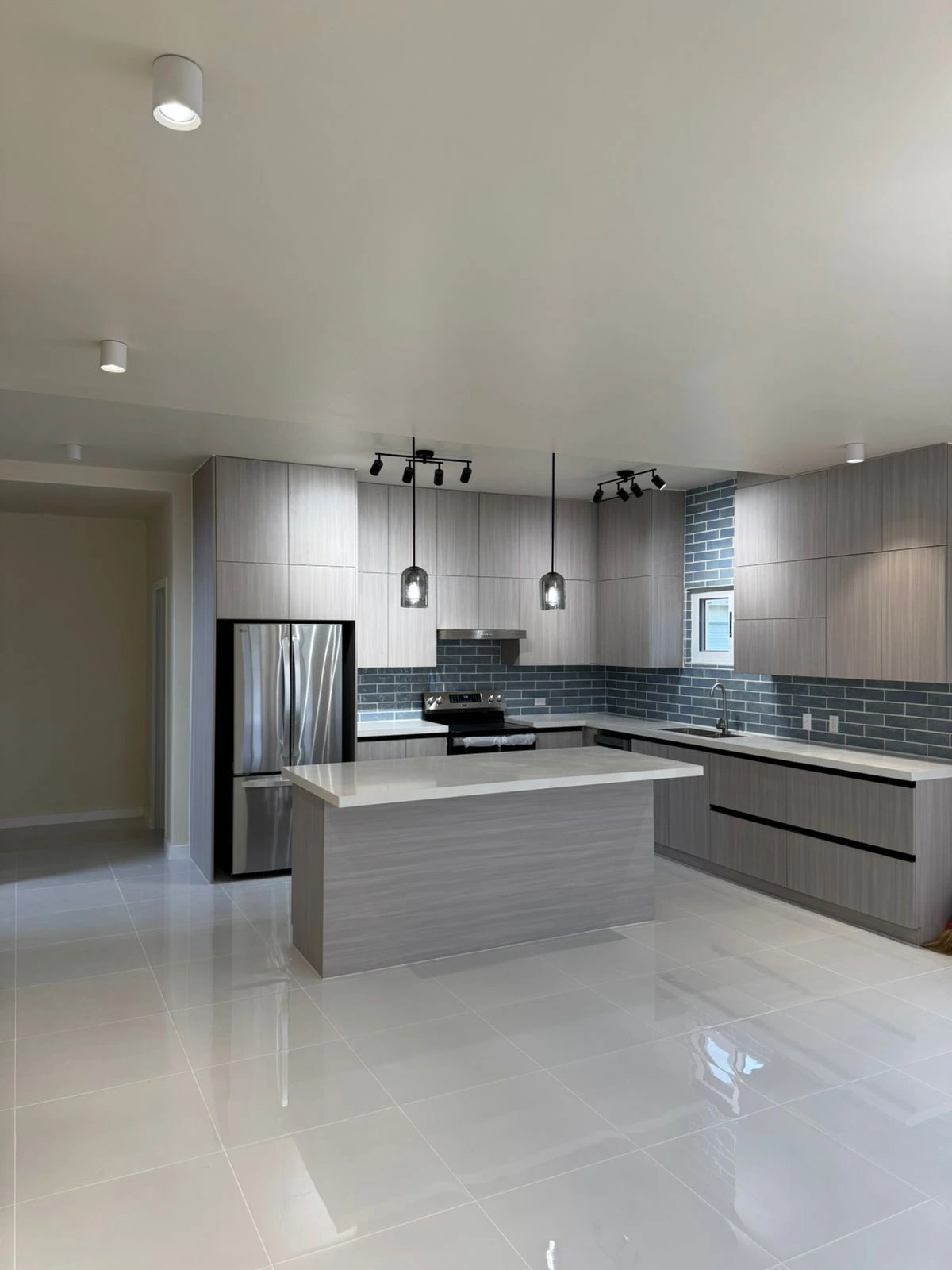 Guam Villa practical kitchen with grey wood-grain cabinets and island